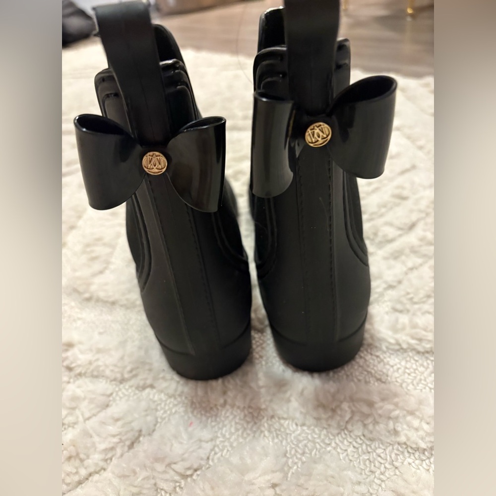 Black rain boot with bow on back, size 10